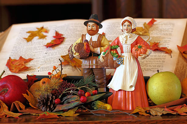 Thanksgiving Thanks Traditional figures portrayed in front of a bible.  pilgrim stock pictures, royalty-free photos & images