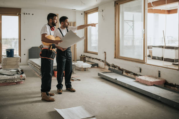 That thing is next on our housing plan! Full length of construction workers analyzing blueprints in the apartment while one of them is aiming at distance. home improvement stock pictures, royalty-free photos & images