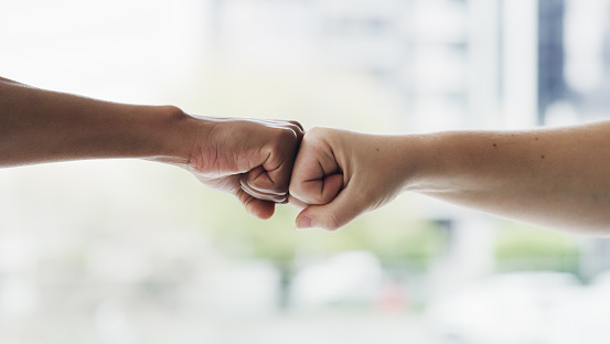 Closeup shot of two unrecognisable people giving each other a fist bump
