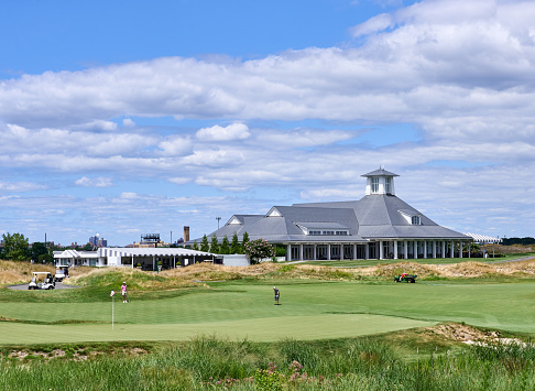 New York, NY - August 13, 2022: The 18th green and the clubhouse of Trump Golf Links at Ferry Point, Bronx, a NYC public golf course designed by Jack Nicklaus.