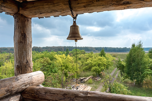 An old wooden observation tower. The alarm bell is suspended to guard the entrance to the fortress.