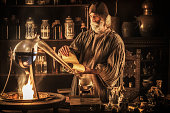 Medieval alchemist distilling in his laboratory