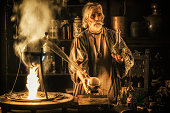 Medieval alchemist distilling in his laboratory