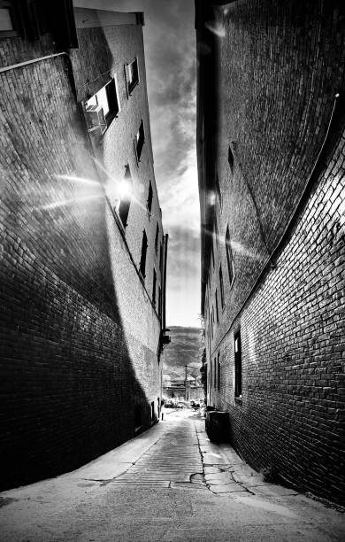 the alleyway between two towering brick buildings - abstract; black & white touring historic brattleboro, vt - usa samuel howell stock pictures, royalty-free photos & images