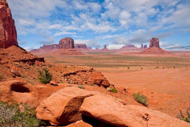 Monument Valley from North Window Overlook The American Southwest has some amazing landscapes, especially the colorful rock formations. The background of blue sky and puffy clouds adds color, depth and contrast to the scene. This view of rock formations is in Monument Valley Tribal Park in Arizona, USA. jeff goulden southwest usa stock pictures, royalty-free photos & images