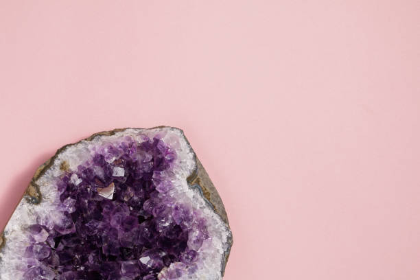 The amethyst stone on pastel pink background. Minimalism flat lay style. The amethyst stone on pastel pink background. Minimalism flat lay style. amethyst stock pictures, royalty-free photos & images
