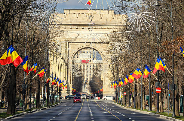 The Arch of Triumph (Arcul de Triumf) from Bucharest Romania The Arch of Triumph (Arcul de Triumf) from Bucharest Romania, National Day with romanian flags, view from Kisseleff Avenue. romania stock pictures, royalty-free photos & images