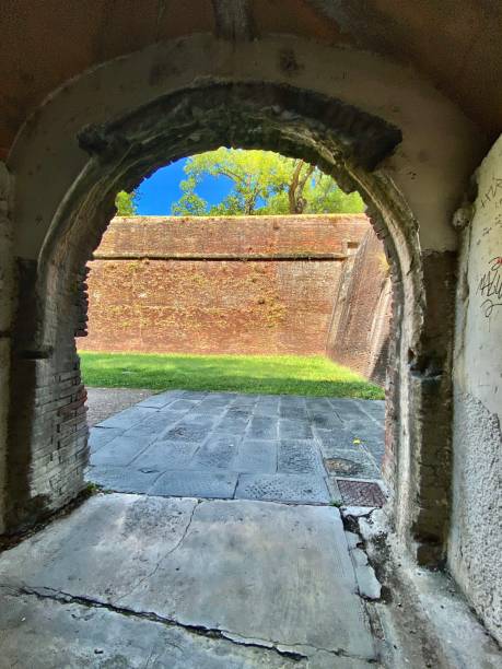 the arched stone footpath opening to the fortified walled city of lucca, tuscany, italy. stock photo