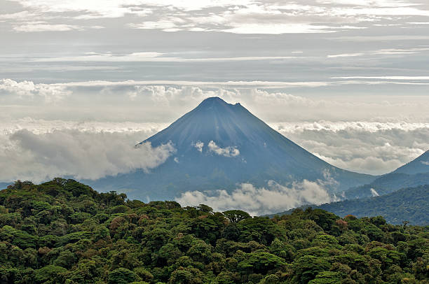 The Arenal Volcano between layers of cloud The Arenal Volcano seen from the Monteverde Cloud Forest. monteverde stock pictures, royalty-free photos & images