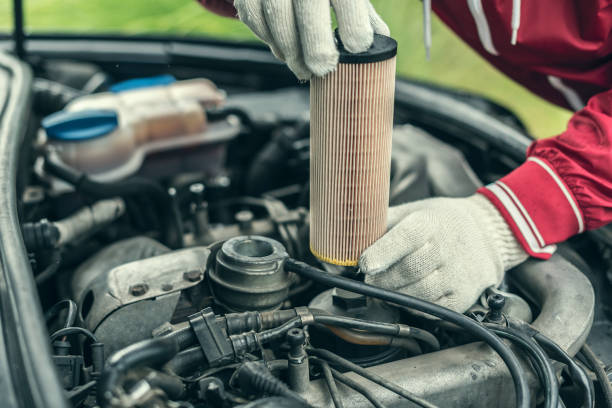The auto mechanic replaces the car's oil filter Auto mechanic replaces the car's oil filter. filtration stock pictures, royalty-free photos & images