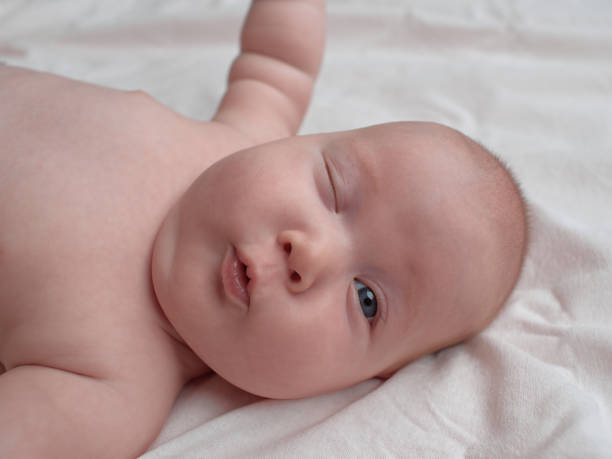 The baby winks at the frame. stock photo