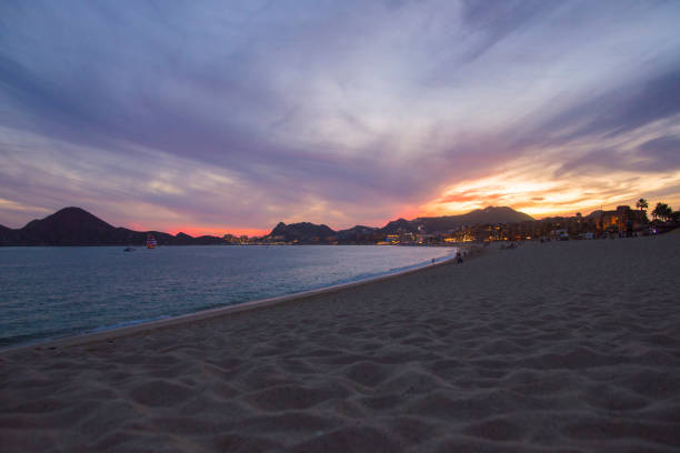 The Bay of Cabo San Lucas During a Beautiful Sunset This is a view of the bay near Cabo San Lucas during a beautiful winter sunset.  Visible are the lights of the city as well as the sandy beaches that surround the bay. has san hawkins stock pictures, royalty-free photos & images