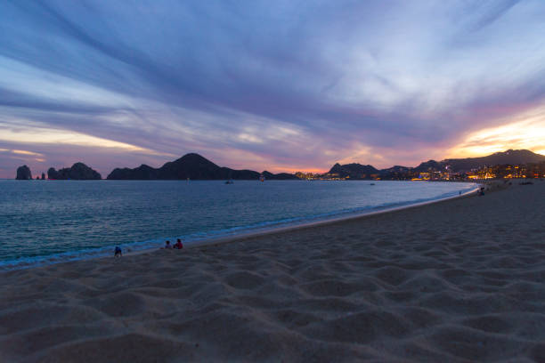 The Bay of Cabo San Lucas During a Beautiful Sunset This is a view of the bay near Cabo San Lucas during a beautiful winter sunset.  Visible are the lights of the city as well as the sandy beaches that surround the bay. has san hawkins stock pictures, royalty-free photos & images