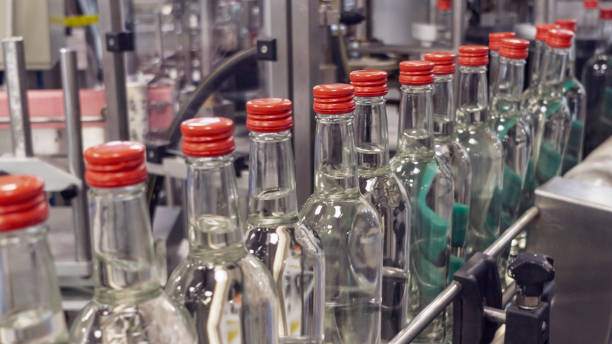 The bottles on the conveyor belt at the plant for bottling of alcoholic beverages, Russian vodka  vodka stock pictures, royalty-free photos & images