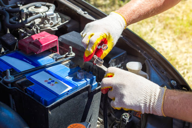 The car mechanic unscrews the car battery holder to repair or replace it. Transport service stock photo