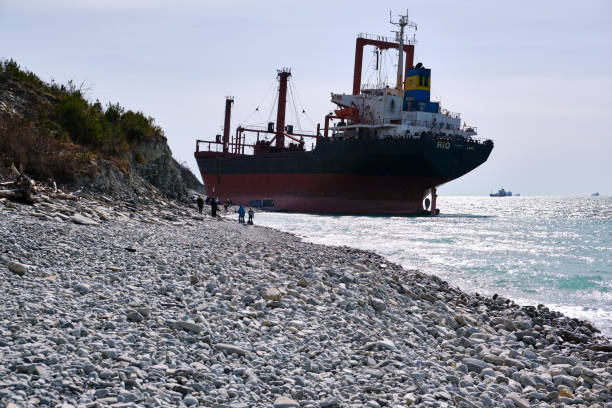 The cargo ship ran aground on a rocky shore. Rio's ship under the flag of Togo. A strong storm washed the ship ashore. Tourists visit the attraction. Gelendzhik, Russia - 09 MARCH 2019. The cargo ship ran aground on a rocky shore. Rio's ship under the flag of Togo. A strong storm washed the ship ashore. Tourists visit the attraction. boat runs aground stock pictures, royalty-free photos & images
