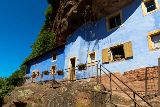 The cave houses, called in french "Maison des Rochers" are located in the village Graufthal, in the commune of Eschbourg, in the Bas-Rhin department. France The blue troglodyte houses in rock face at Graufthal, Bas-Rhin, Alsace, France, Europe bas rhin stock pictures, royalty-free photos & images