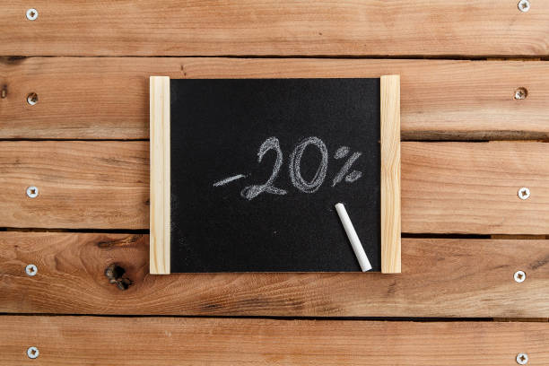 the chalk Board with the inscription -20% on wooden background. the view from the top stock photo