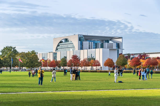 The Chancellery surrounded by colorful trees with tourists in Berlin, Germany stock photo