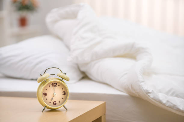 The classic clock on the background of the bed stock photo