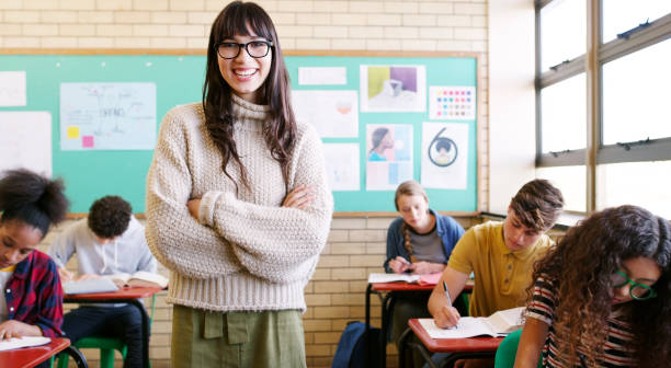 The classroom is where I should be Portrait of a cheerful young teacher giving class to a group of students inside of a school during the day middle school teacher stock pictures, royalty-free photos & images
