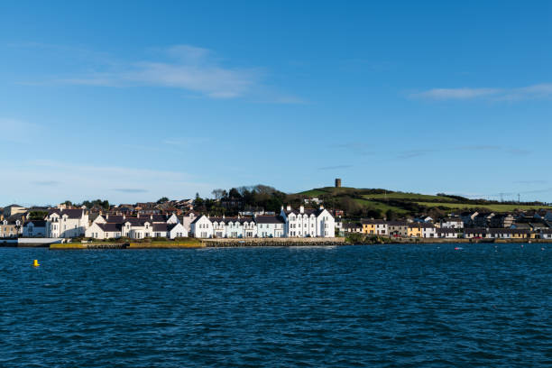 The colorful waterfront of  Portaferry with a hill and green fields above the village along Strangford Lough in County Down, Northern Ireland Waterfront of Portaferry, County Down, Northern Ireland strangford lough stock pictures, royalty-free photos & images