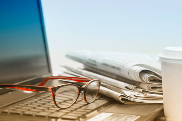 The concept of news. Newspaper, laptop, glasses on your desktop Coffee break. stock photo