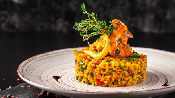 The concept of Spanish cuisine. Paella with seafood, shrimps, squid and greens. Beautiful serving in the restaurant. stock photo