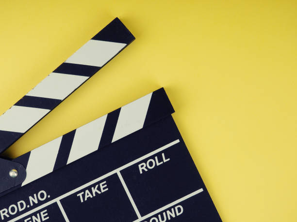 the concept of the film industry, a minimalistic composition on a yellow background with glasses and clapperboard. movies and cinema. stock photo