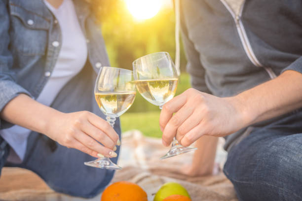 the couple drink an alcohol against the background of the sunshine - spot light orange imagens e fotografias de stock