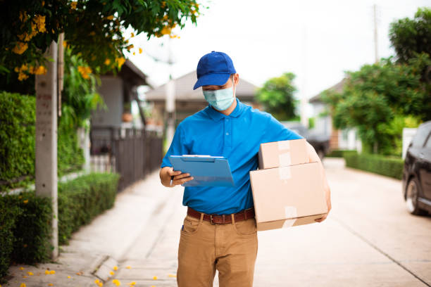 The delivery man was looking for the customer's home to deliver the parcel stock photo