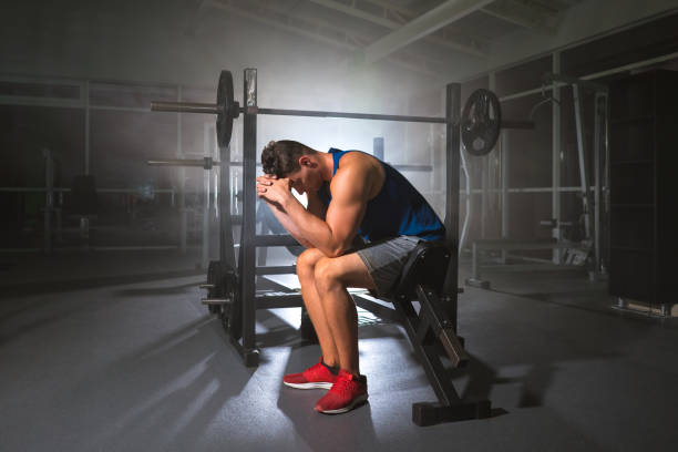 The depressed sportsman sit in the sport center stock photo