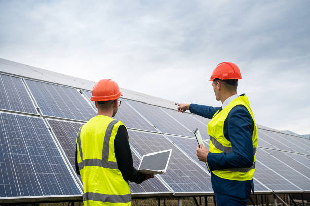 the director of company inspects the work of an employee in  clothing installed solar panels. stock photo