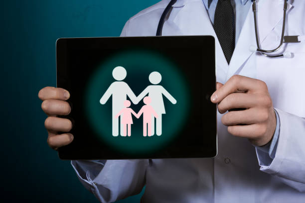 The doctor is holding a tablet with a picture of the family. stock photo