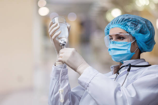 The doctor prepares a system for transfusion of infusion solutions . The doctor prepares a system for transfusion of infusion solutions on a blurred background. anesthetic stock pictures, royalty-free photos & images