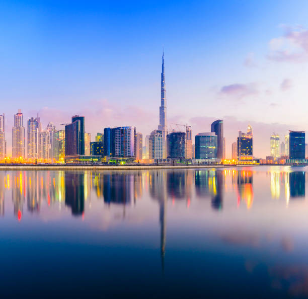 The Downtown Dubai City Skyline at Sunset Illuminated Reflection in the Still Lagoon Waters burj khalifa stock pictures, royalty-free photos & images