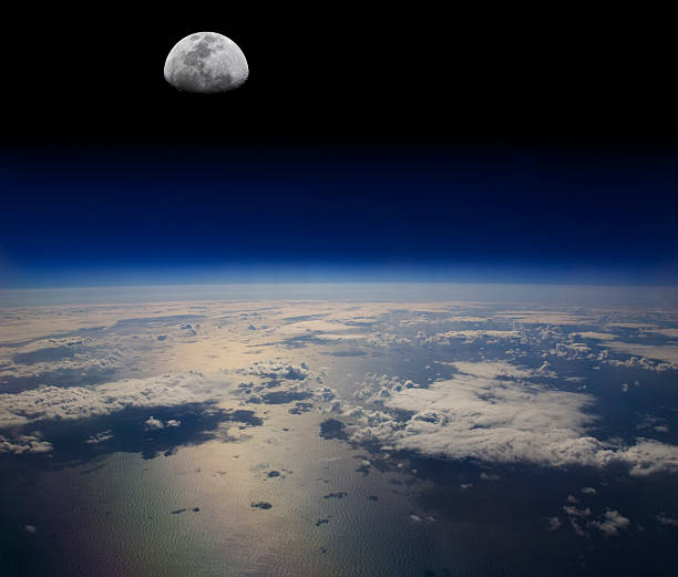 The Earth in space and the Moon The Moon in space above the surface of the ocean. Reflected light from the sea a cloud shadows make for a dramatic composition. stratosphere stock pictures, royalty-free photos & images