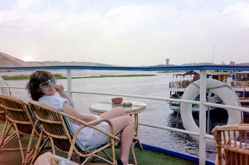 Upper Egypt - The eighties.  A young women is relaxing on the sun deck of a Nile cruiser. The image were scanned from old negative.