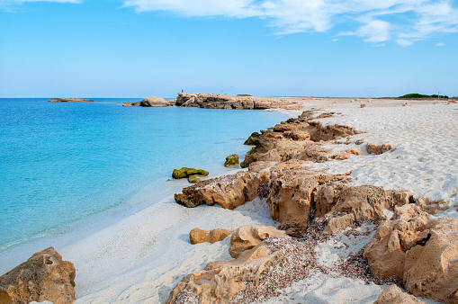 Sandy beach of Is Arutas with beautiful clear sea with clear blue water on the island of Sardinia in Italy.