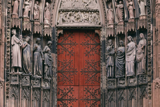 The entrance to the grand cathedral in Strasbourg, the main religious landmark of the city The entrance to the grand cathedral in Strasbourg, the main religious landmark of the city. The numerous sculptures adorning the cathedral are clearly visible. notre dame de strasbourg stock pictures, royalty-free photos & images