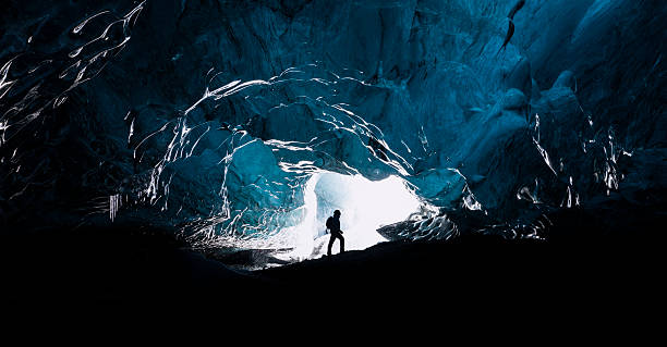 The explorer Man exploring an amazing glacial cave in Iceland cave stock pictures, royalty-free photos & images