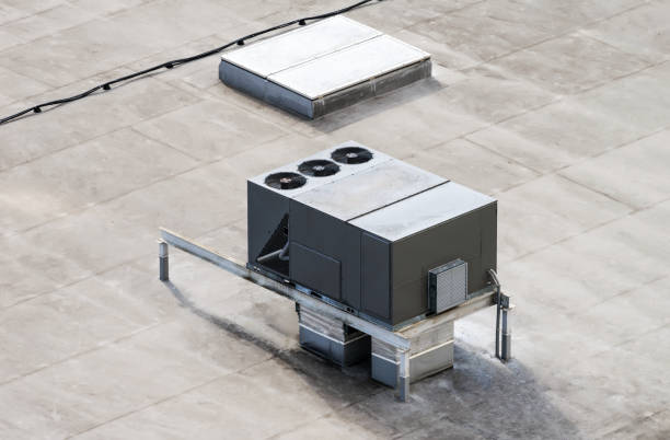 The external units of the commercial air conditioning and ventilation systems are installed on the roof of an industrial building stock photo