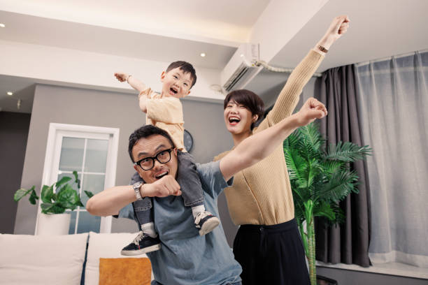 The father carried his son and played with his mother in the living room stock photo