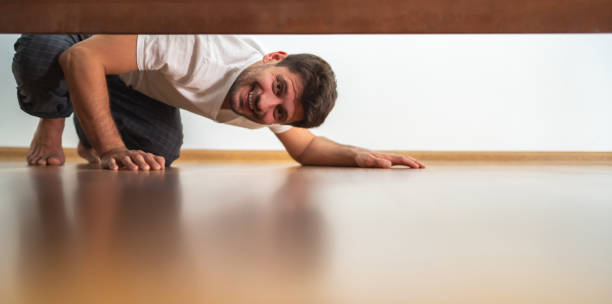 the-fellow-looking-under-the-bed-picture-id1077193858