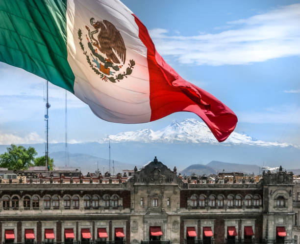 The flag of Mexico in the Zocalo square in Mexico City with the Iztaccíhuatl volcano stock photo