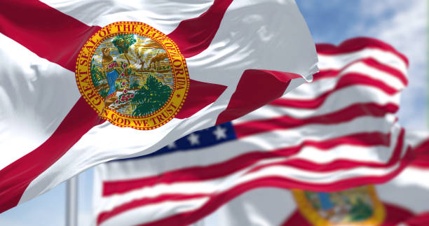 The Florida state flag waving along with the national flag of the United States of America The Florida state flag waving along with the national flag of the United States of America. In the background there is a clear sky. florida us state photos stock pictures, royalty-free photos & images