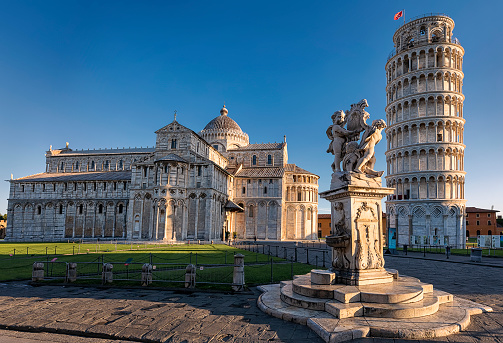 The Fontana dei Putti (Fountain with Angels),  Pisa Cathedral and Leaning Tower of Pisa at sunrise. Pisa ,Tuscany region, Italy. Golden autumn in Pisa