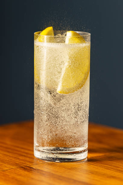 The Gin Tonic Gin Tonic Cocktail. Gin, tonic, lemon wedge, ice and bitter. Cocktail on wooden bar. sour taste stock pictures, royalty-free photos & images