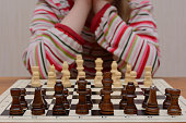 istock the girl thinks through a course in wooden chess 1180591504