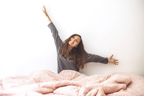 The girl woke up The girl woke up, stretched out her arms and rejoices at the coming of the morning. waking up stock pictures, royalty-free photos & images